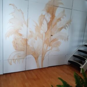 muurschildering in natureltinten gemaakt van pampasgras op een lichte metalen achterwand in een woonkamer met een houten vloer die moet combineren hierbij.
